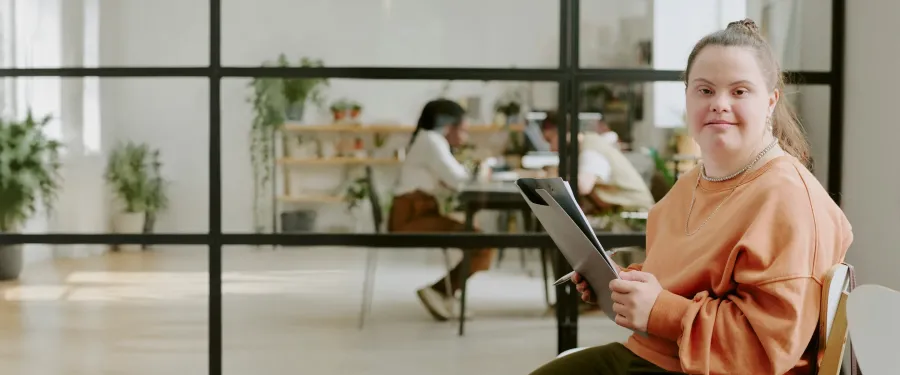 A young woman smiling in a bright, welcoming office