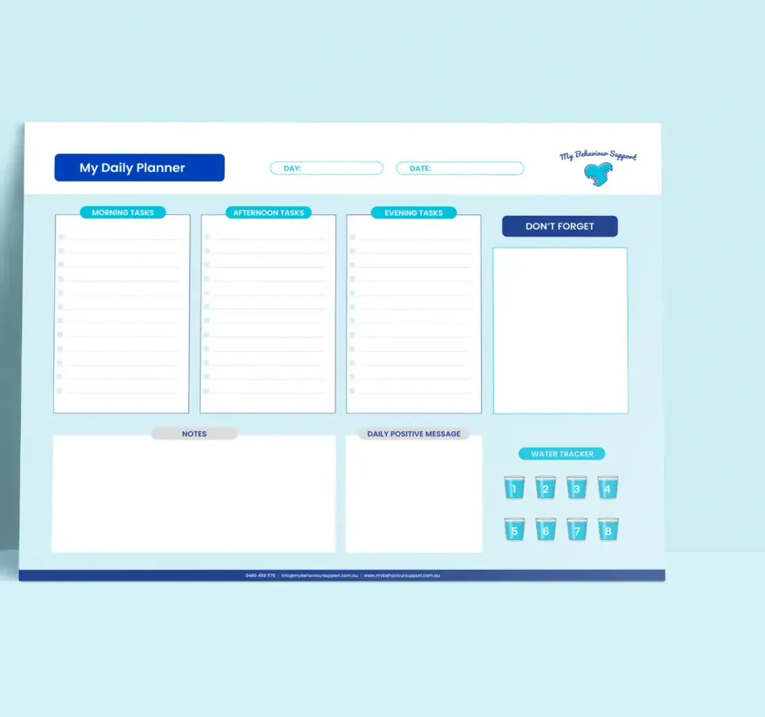 A printed My Daily Planner chart leaning against a pale blue wall